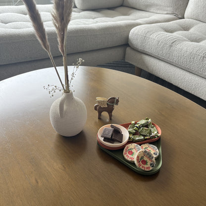 Bandejas grupal en mesa de centro con jarron blanco con pampas y figura de caballo, ambiente de sala completo