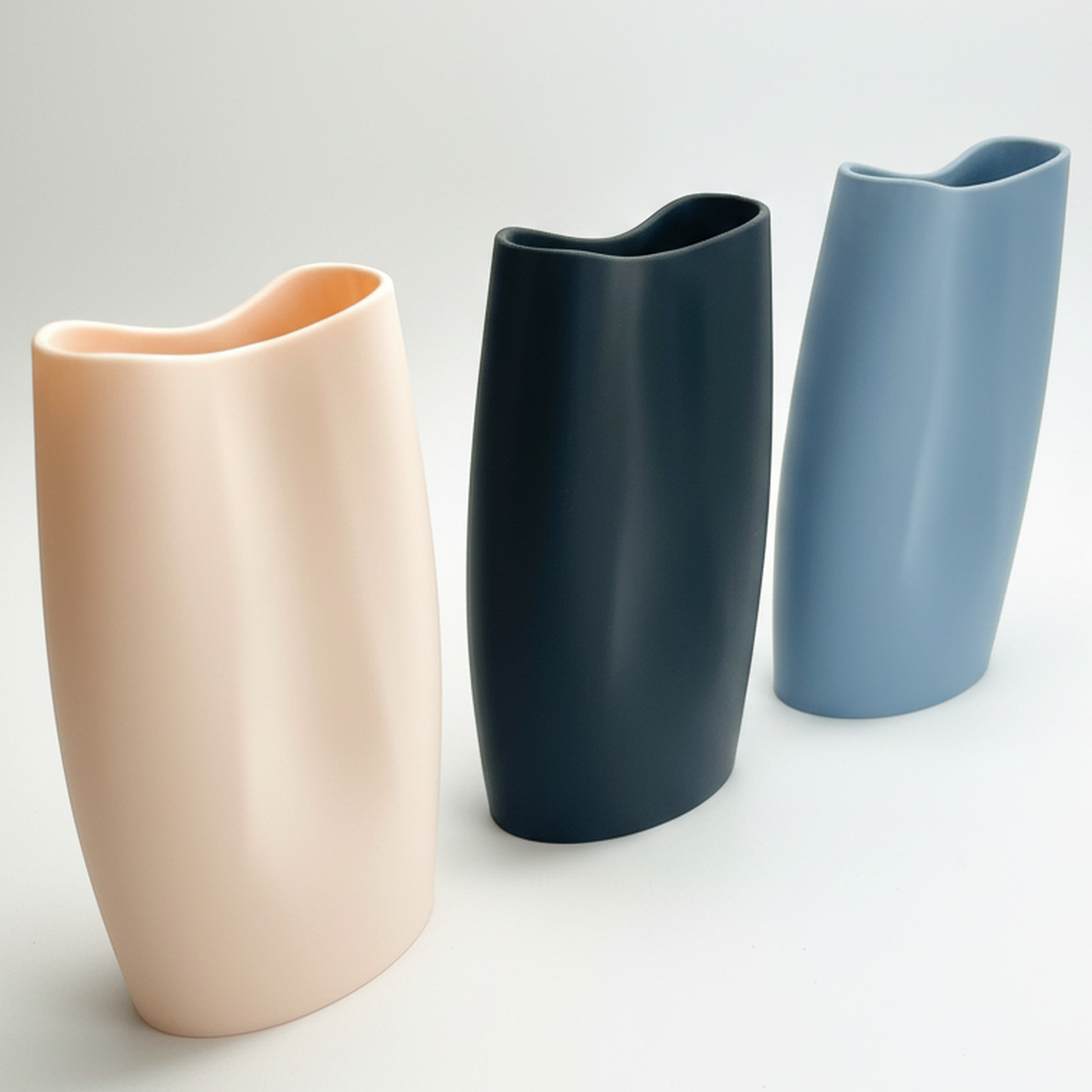 Los 3 jarrones juntos vacios (beige, charcoal, blue grey), vista 3/4 mostrando las variantes