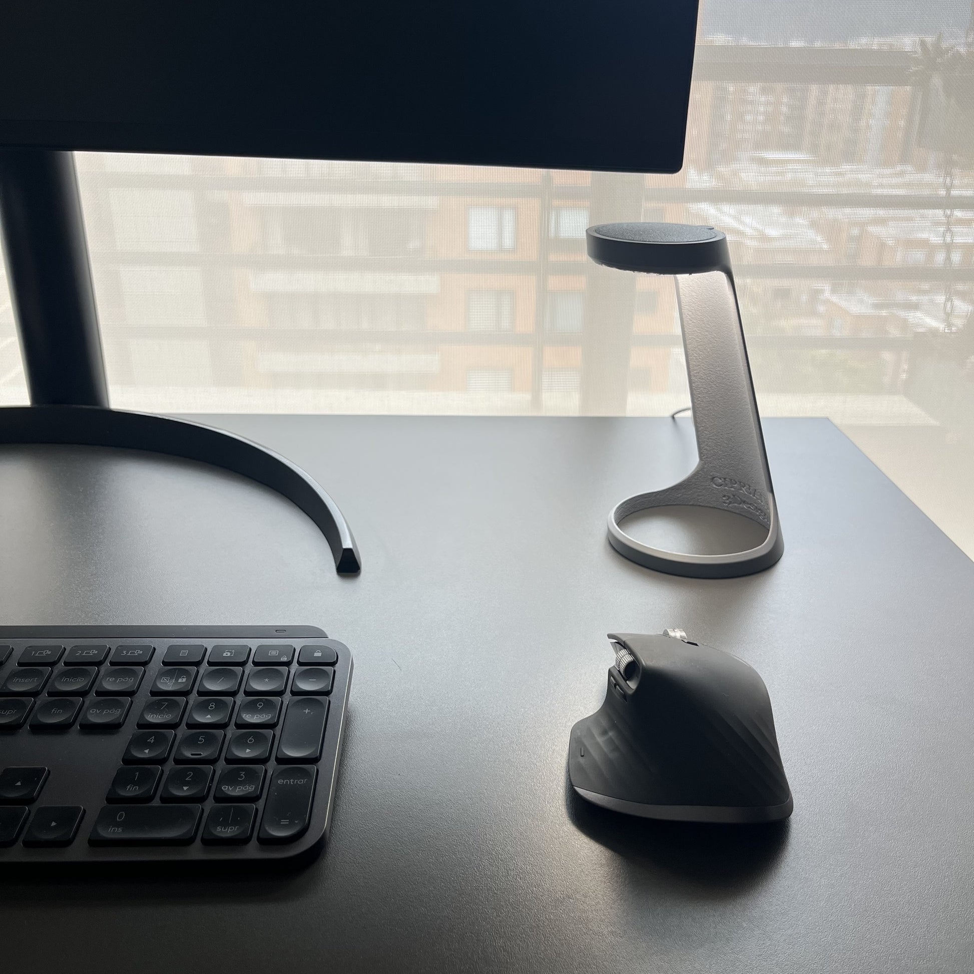 Lampara Ash Gray en escritorio con monitor y ventana grande con vista exterior