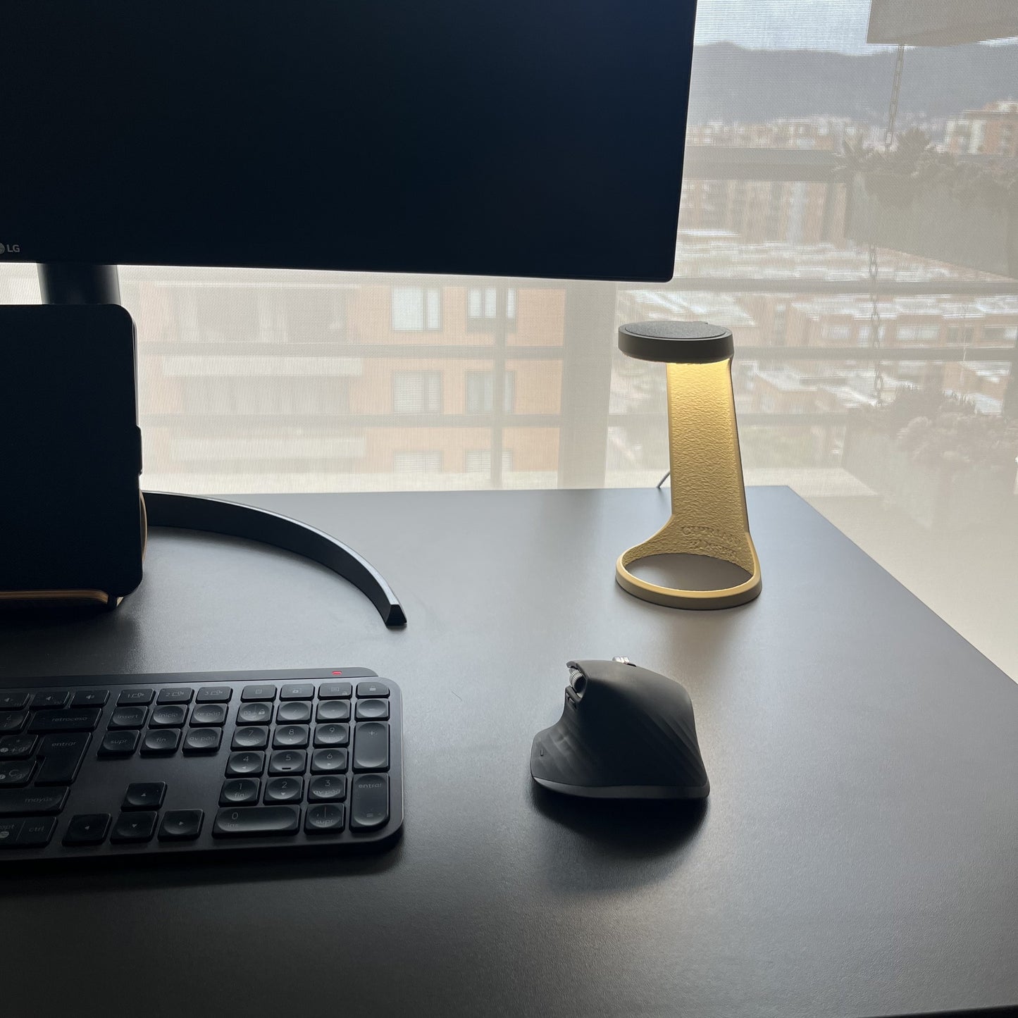 Lampara Desert Tan en escritorio con monitor LG y ventana de fondo