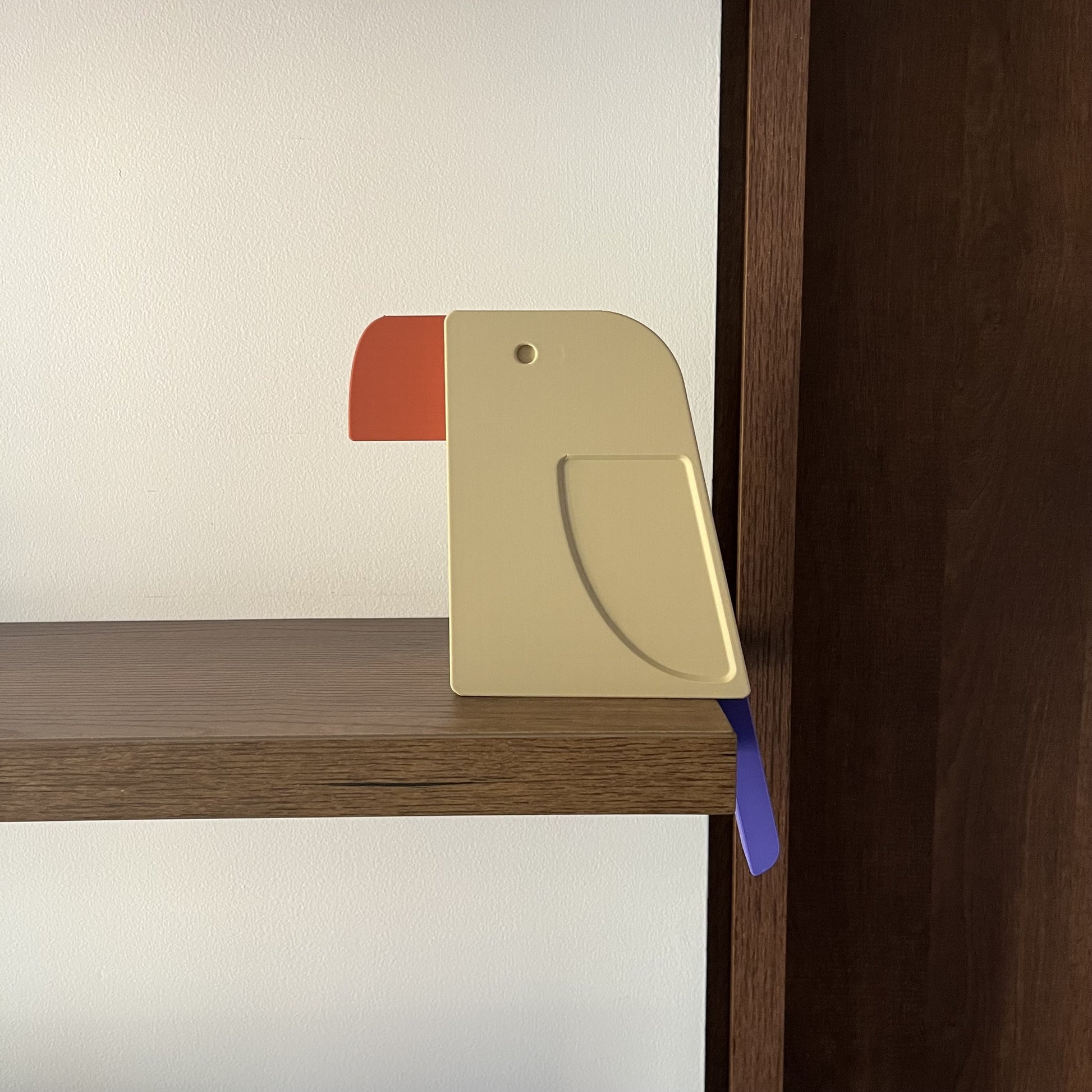 Pieza multicolor — perfil lateral limpio y centrado sobre pared blanca