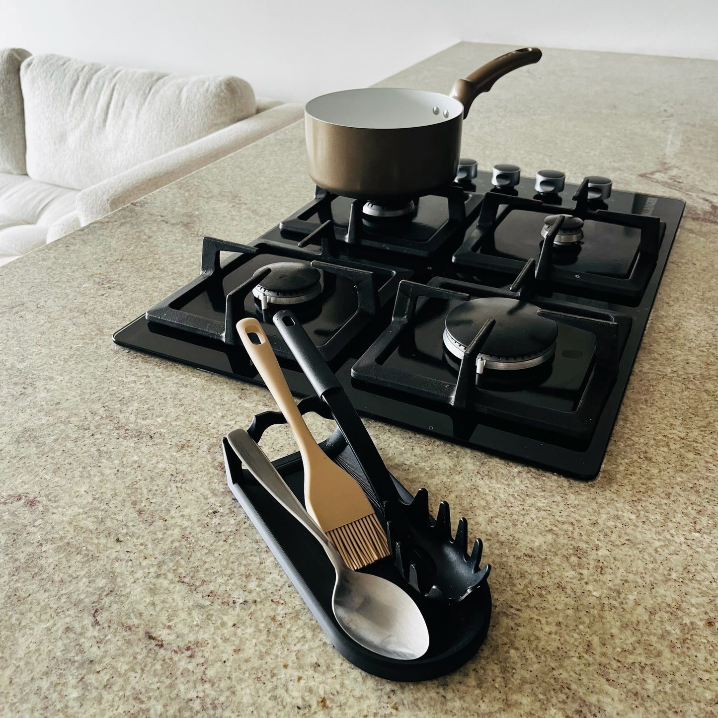 Soporte Charcoal en uso real con espatula, brocha y cuchara, estufa al fondo