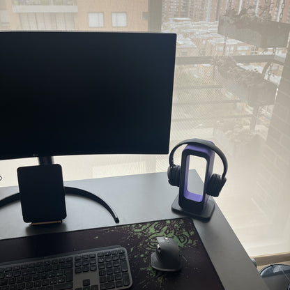 Soporte Charcoal con audifonos Sony blancos en escritorio con vista a ventana, luz natural