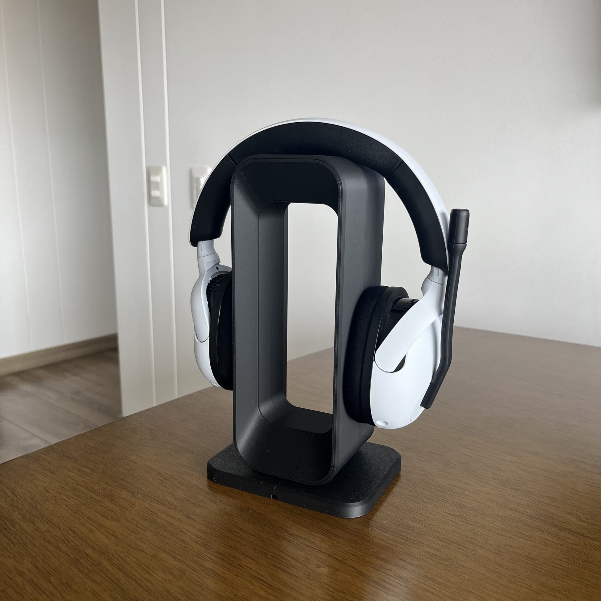 Soporte Charcoal + Purple con audifonos en mesa de madera, ambiente calido del hogar